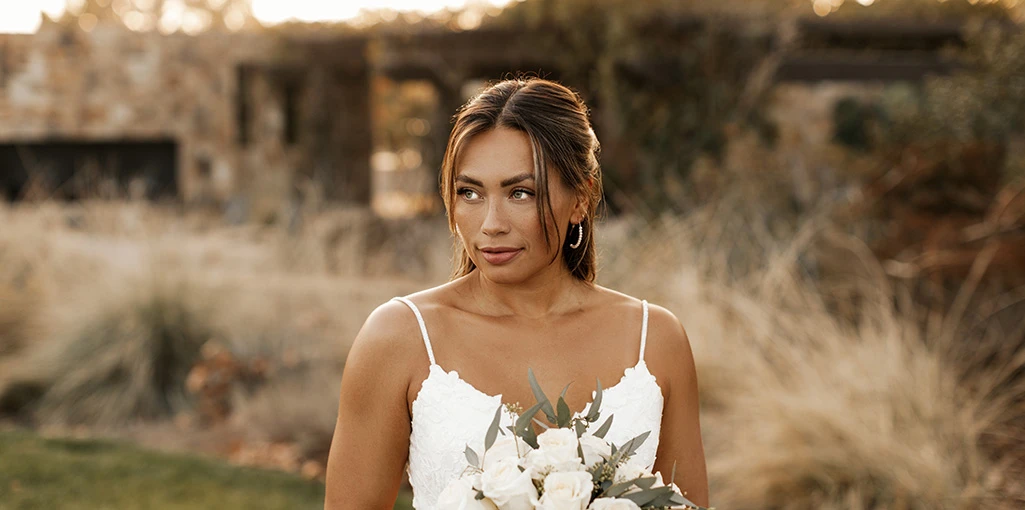 Bride holding flowers wearing a spaghetti strap wedding dress